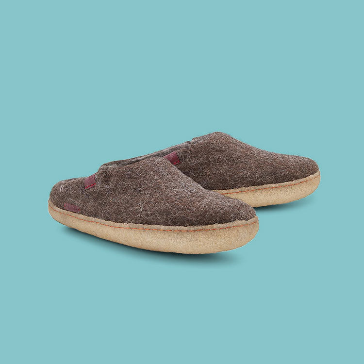 Betterfelt Classic Slipper in Brown Wool Felt With Rubber Soles Against a Blue Colored Backdrop