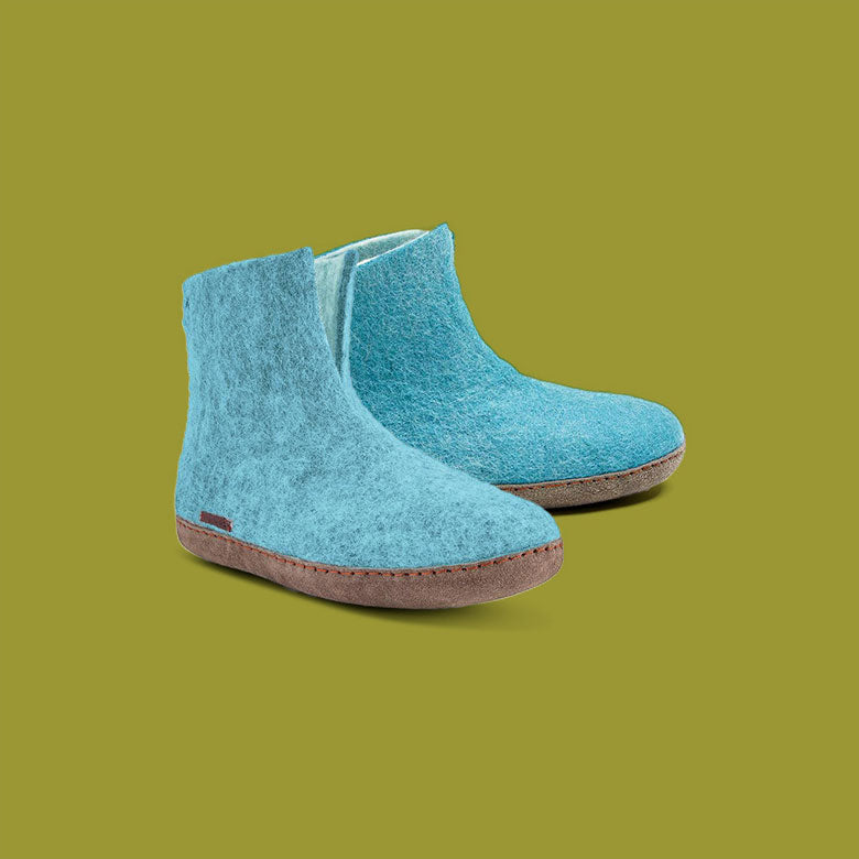 Betterfelt High Boot Slipper in Light Blue Wool Felt With Leather Soles Against an Olive Colored Backdrop