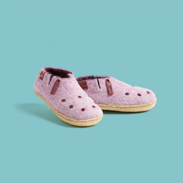 Betterfelt Kinder Slipper in Pink Wool Felt With Crepe Rubber Soles Against a Blue Colored Backdrop